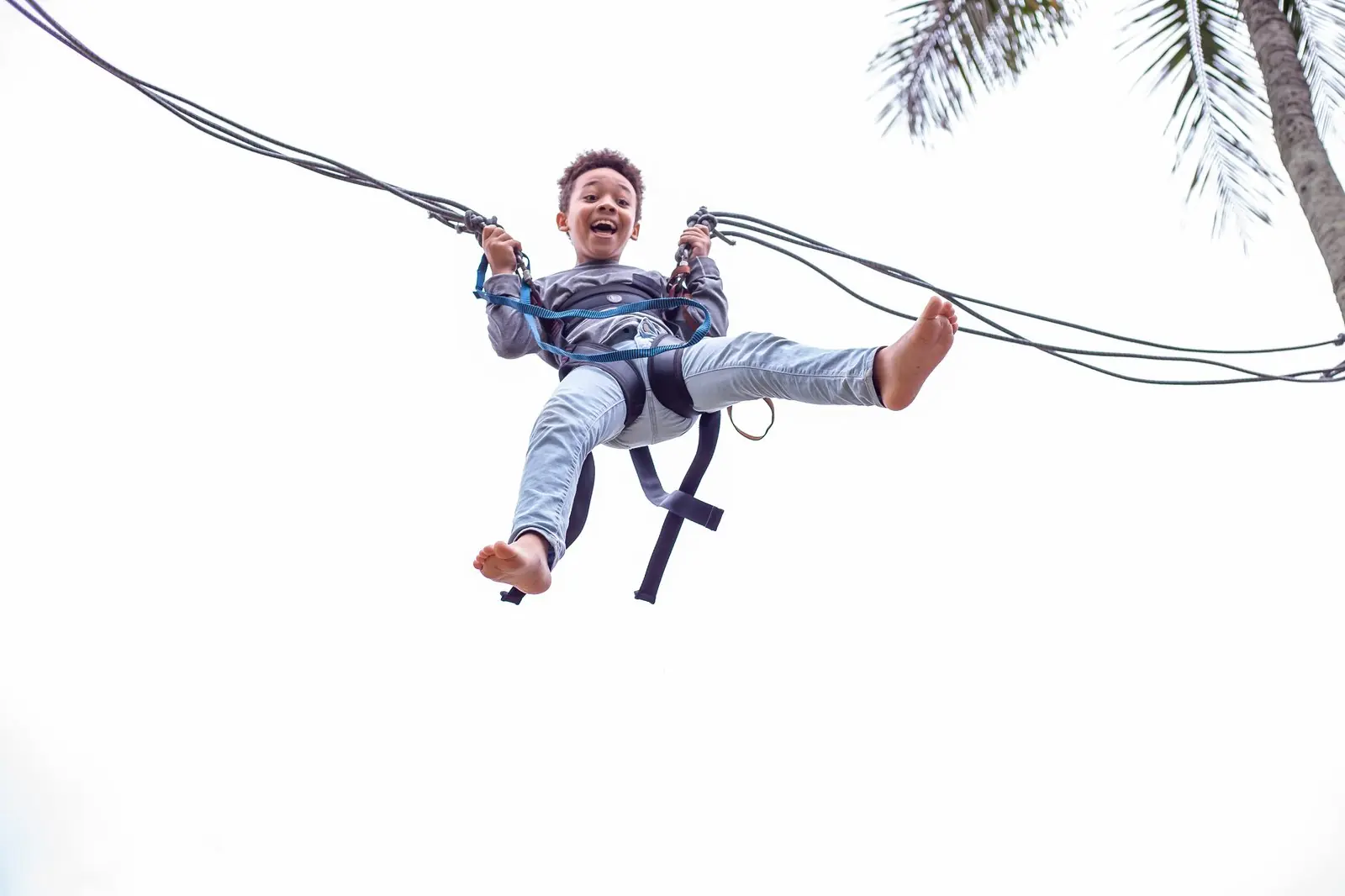 Criança sorrindo em brinquedo bungee ao ar livre
